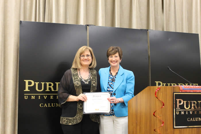 Photograph of 2014 award recipient Lorna Hecker receiving award certificate from Peggy S. Gerard.